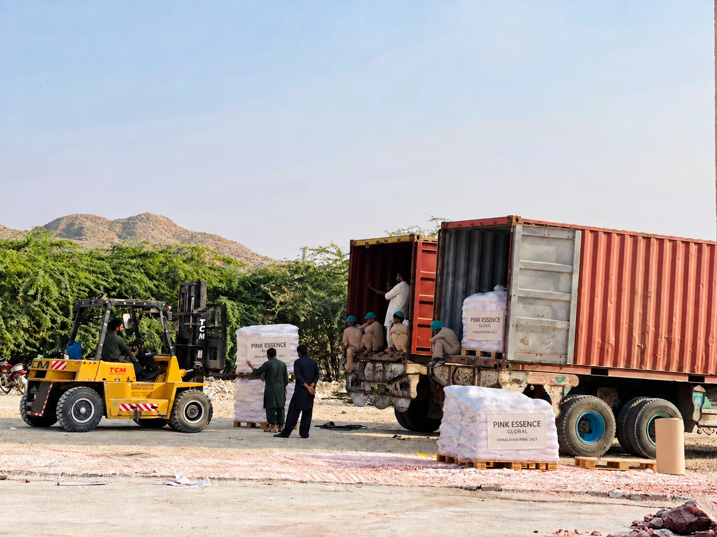 Factory dispatch yard with forklift, wrapped pallets and shipping containers; digitally added Pink Essence pallet labels